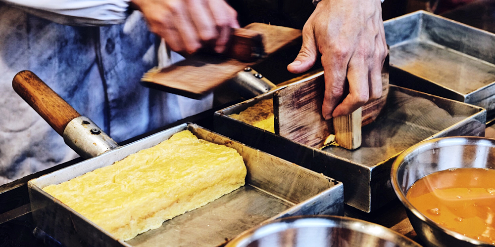 Japanisches Omelett wird in Tamago-Pfanne zubereitet.|default:Tamagoyaki|default:.NAME